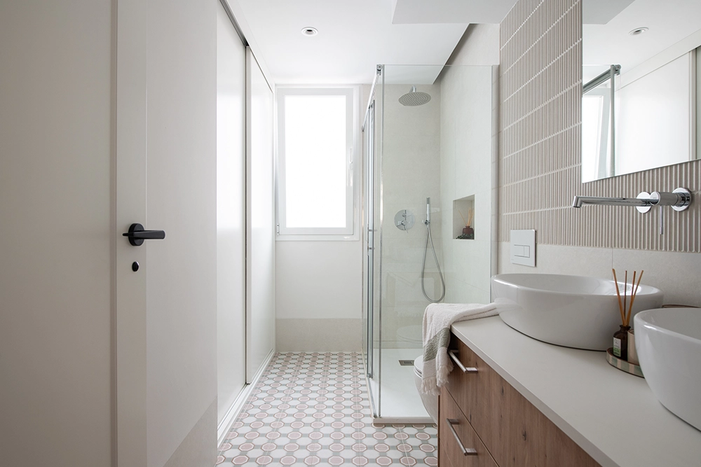 Reforma integral de vivienda en Sevilla con proyecto de interiorismo residencial, baño moderno con ducha, mobiliario a medida y diseño funcional.