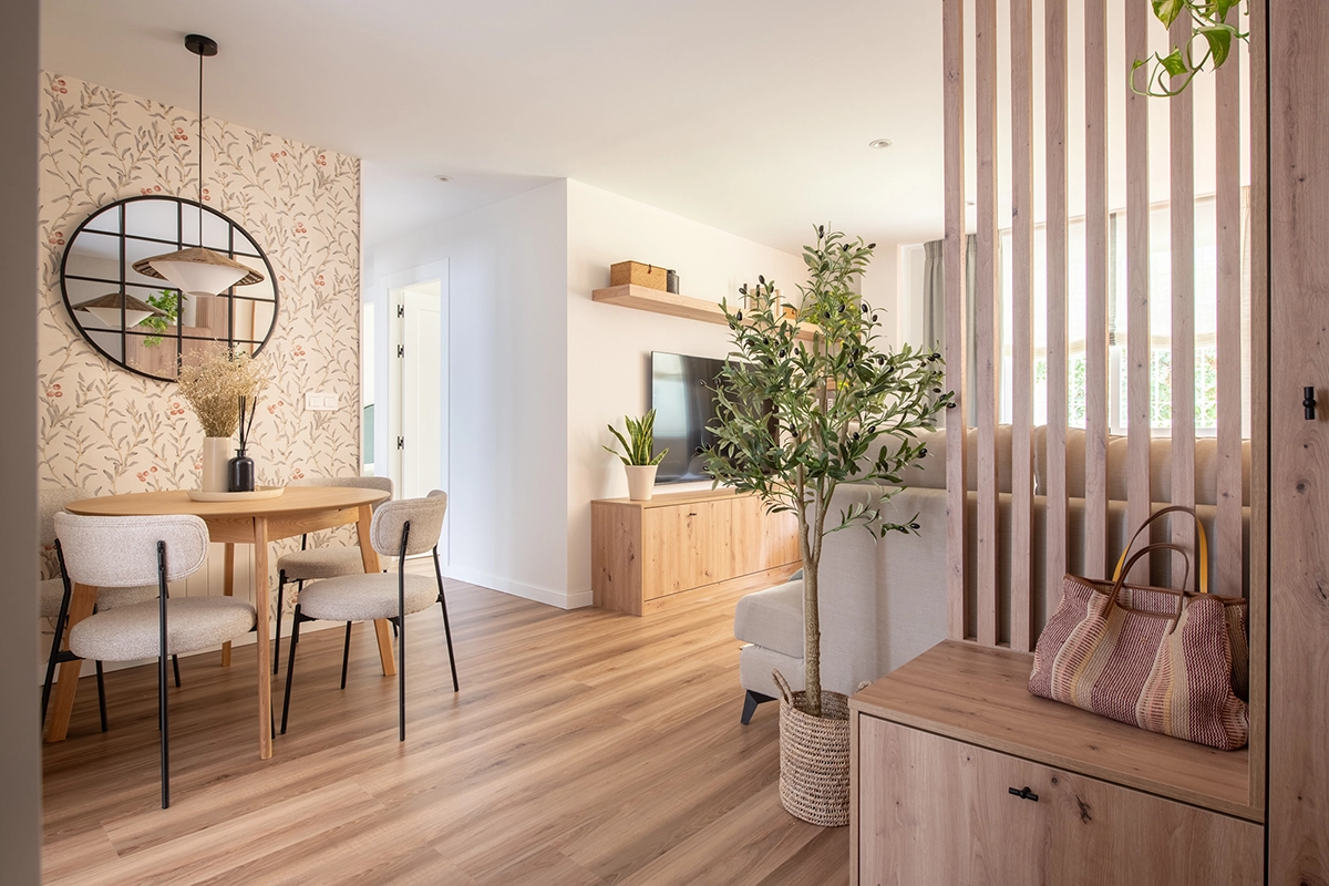 Interiorismo residencial en Sevilla con salón de diseño cálido, materiales naturales, mobiliario personalizado y distribución optimizada en vivienda reformada.