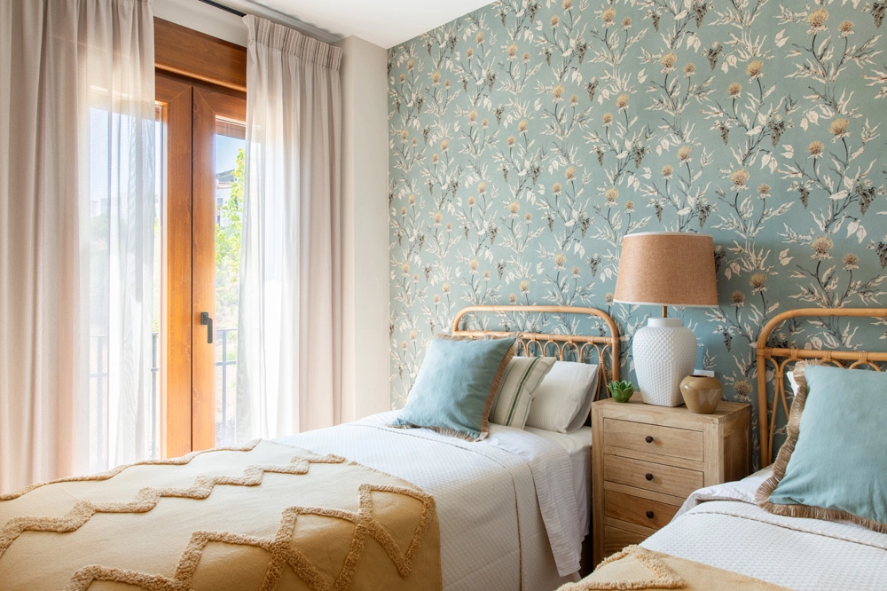 Dormitorio de invitados en Casa El Pantano, proyecto de interiorismo en Zufre, Huelva, con papel pintado botánico, mobiliario ligero y decoración cálida de inspiración natural.